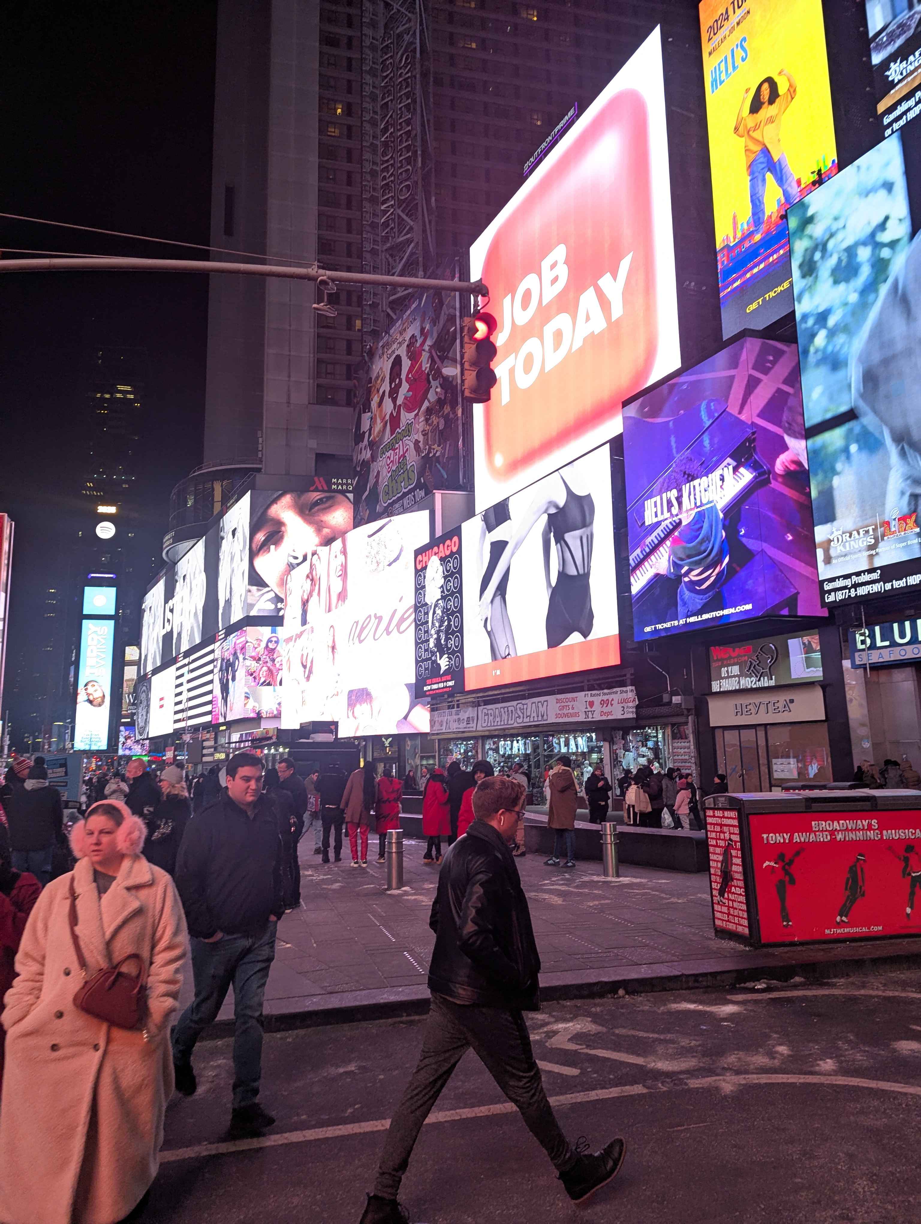 Times Square at night. It looks like daylight because of all the lights.