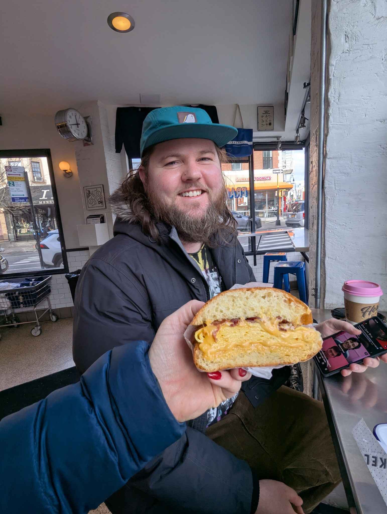 Jacob and Rachel's hand, with the sandwich they go at Frankels.