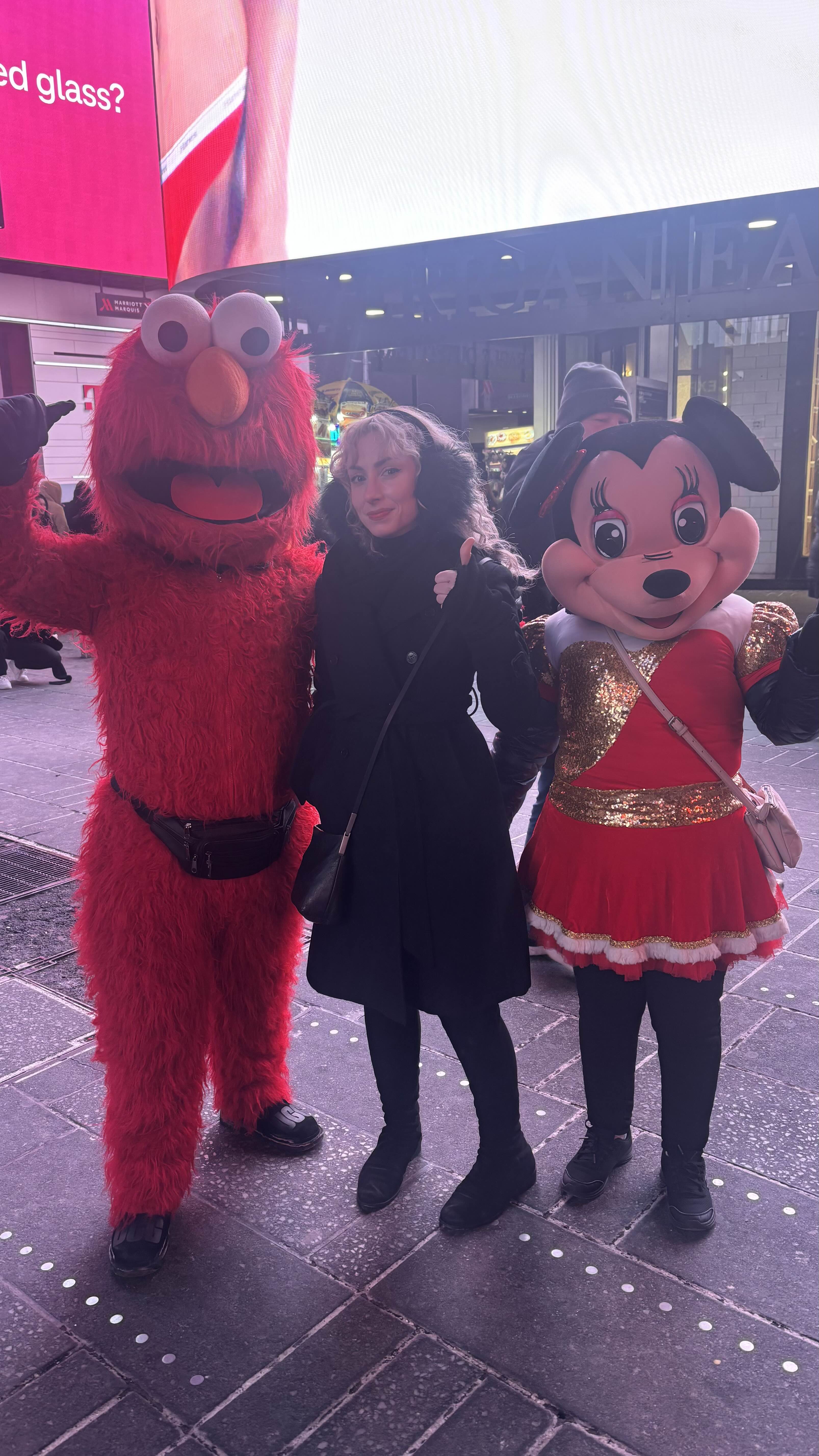 Abbie getting a picture with Elmo(and the Minnie Mouse).