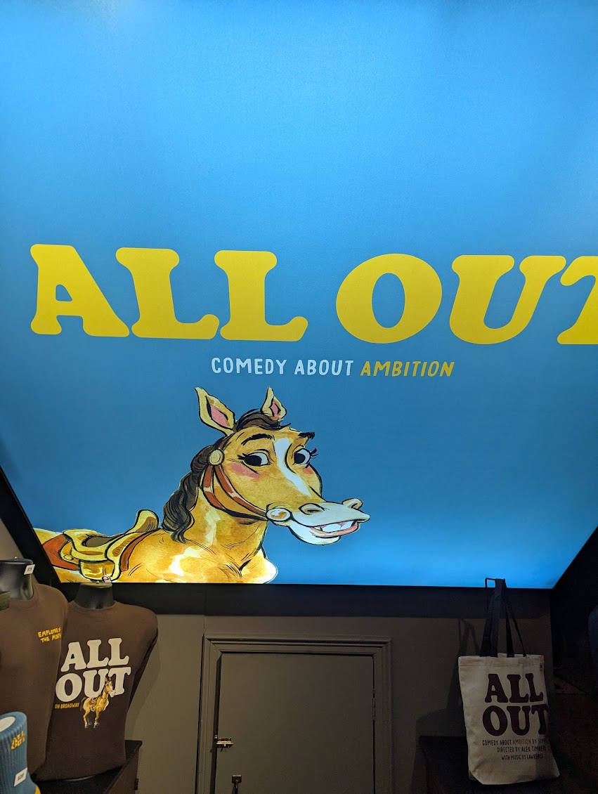 The merch booth and sign.